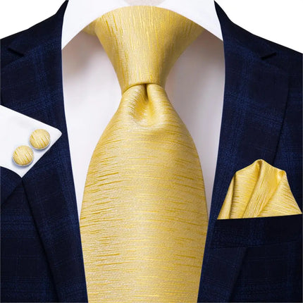 collection of gold ties with matching cuff links and pocket square